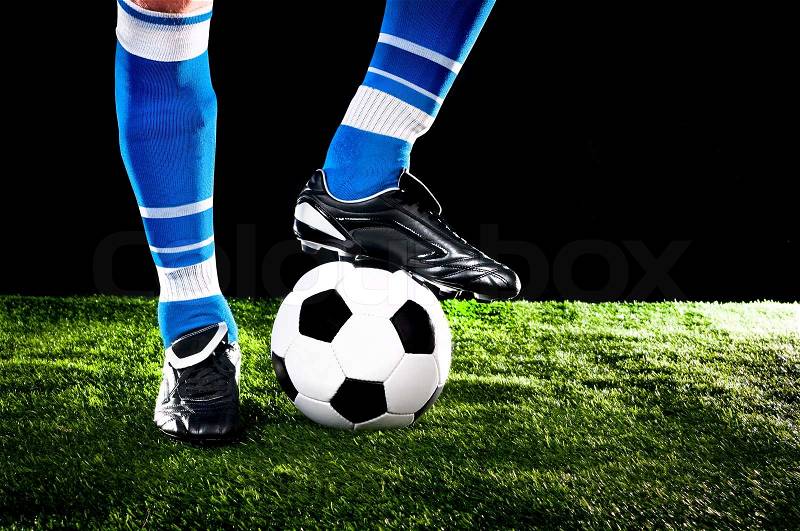 Soccer ball with his feet on the football field, stock photo