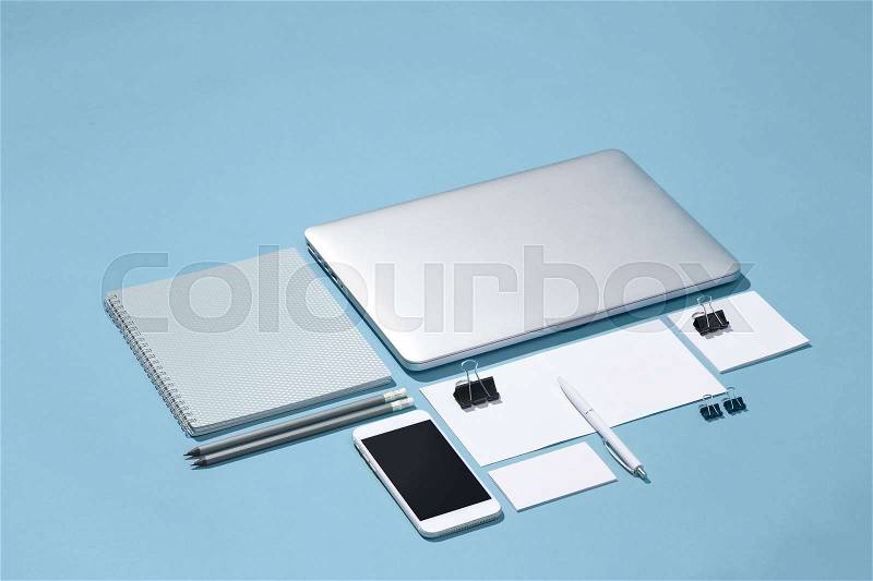 The laptop, pens, phone, note with blank screen on table. Mockup concept, stock photo