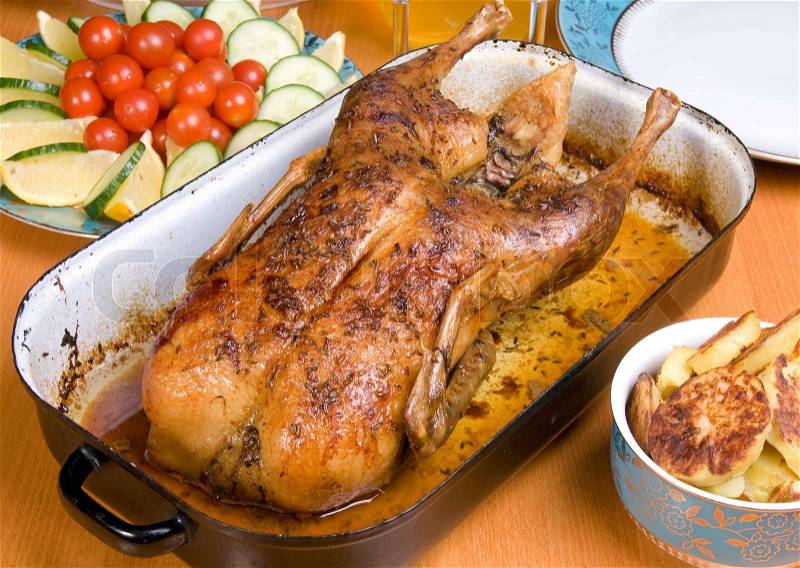 Roasted duck in a pan on the table, stock photo