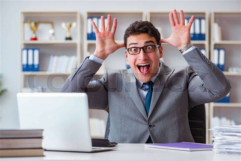Funny businessman clown acting silly in the office, stock photo