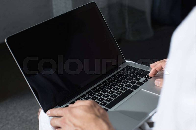 Cropped shot of man using laptop with blank screen, stock photo