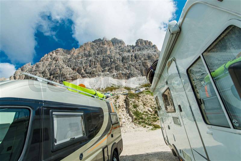 Scenic Camper Vans Camping. Two Motohomes and the Alpine Scenery. Small Class A Motoroaches Rving in High Mountains, stock photo