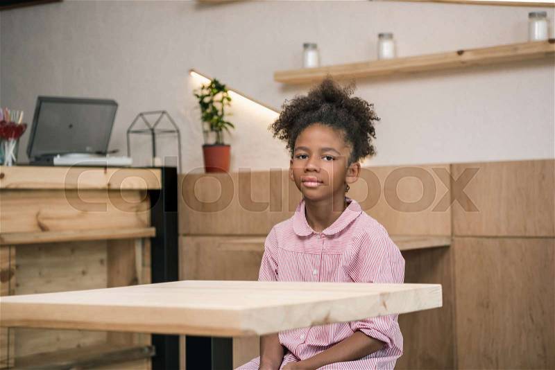 Sad african-american girl sitting alone in cafe, stock photo