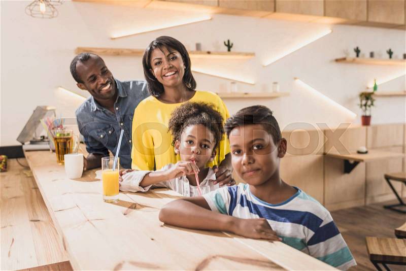 Happy african-american family in cafe at bar counter, stock photo