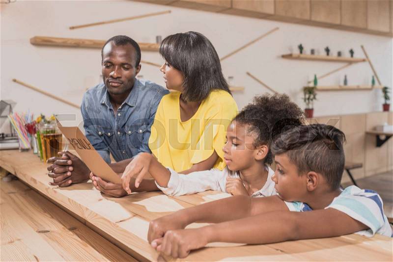 Adorable african-american family in cafe at bar counter, stock photo