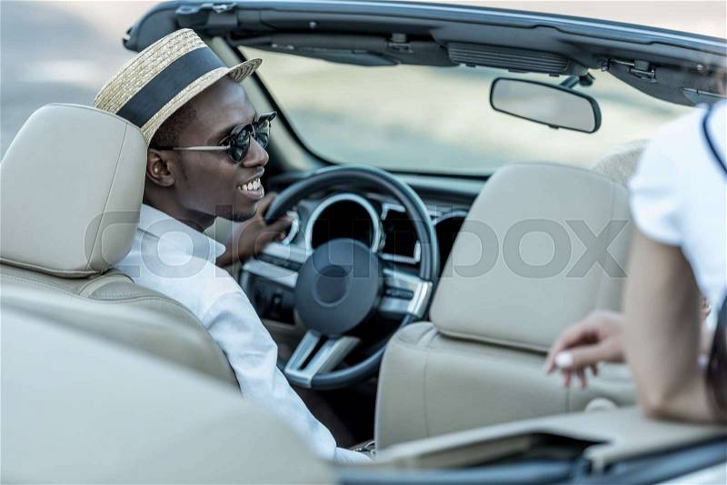 Back view of stylish african american man sitting in car, stock photo