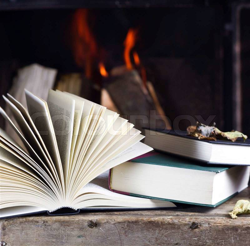 Autumn books in front of a fire, stock photo