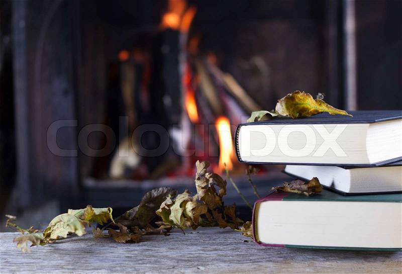 Autumn books in front of a fire, stock photo