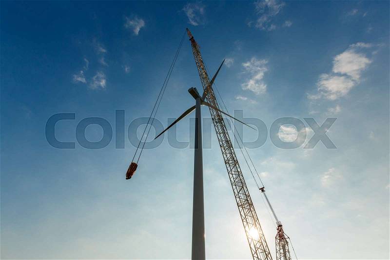 Industrial crane installing wind tubine. Renewable wind energy concept , stock photo