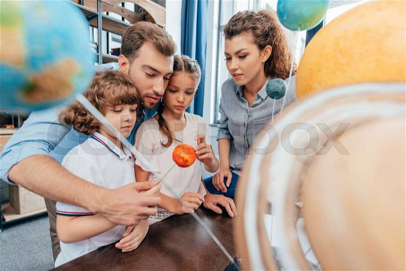 Family making solar system model for school project, stock photo