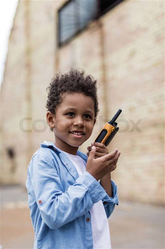 Beautiful smiling afro boy with portable radio set, stock photo