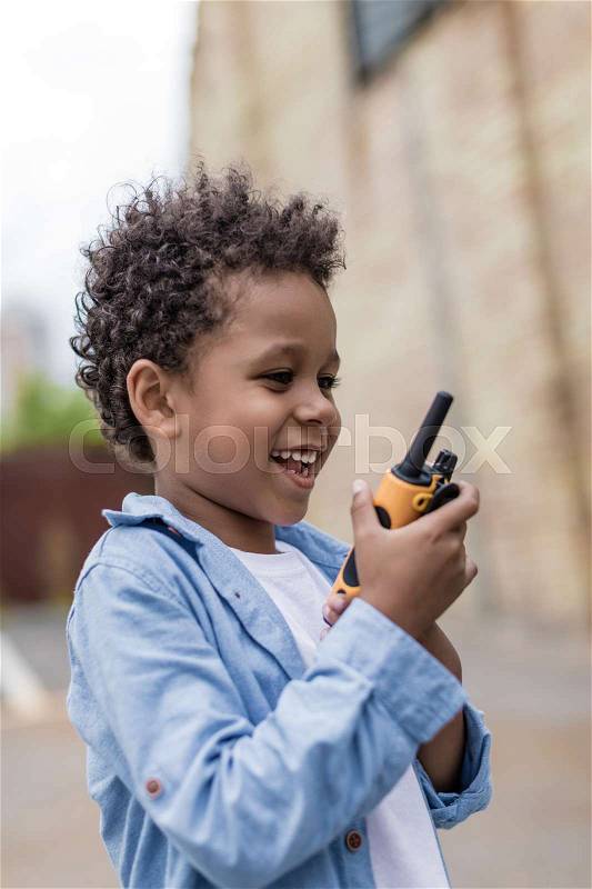Cute smiling afro boy with portable radio set, stock photo