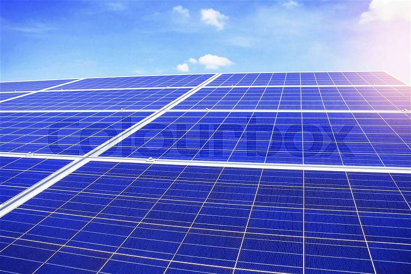 Solar panels on a blue sky with light during the day, stock photo