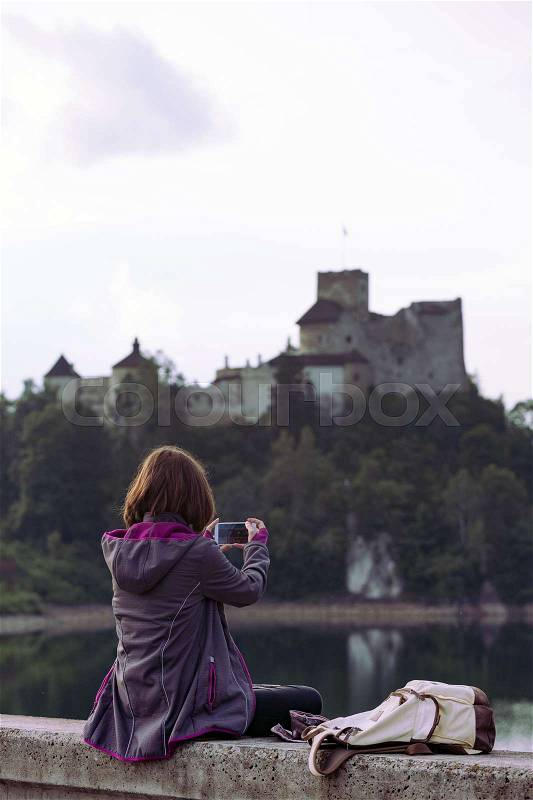 Girl making a photo shoot of castle niedzica with the Smartphone, Poland , stock photo