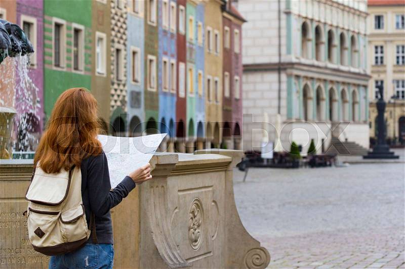 Girl looking at the map standing at the main square Rynek of polish city Poznan , stock photo