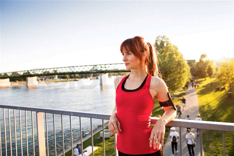 Beautiful fit young runner in the city at the river resting, stock photo