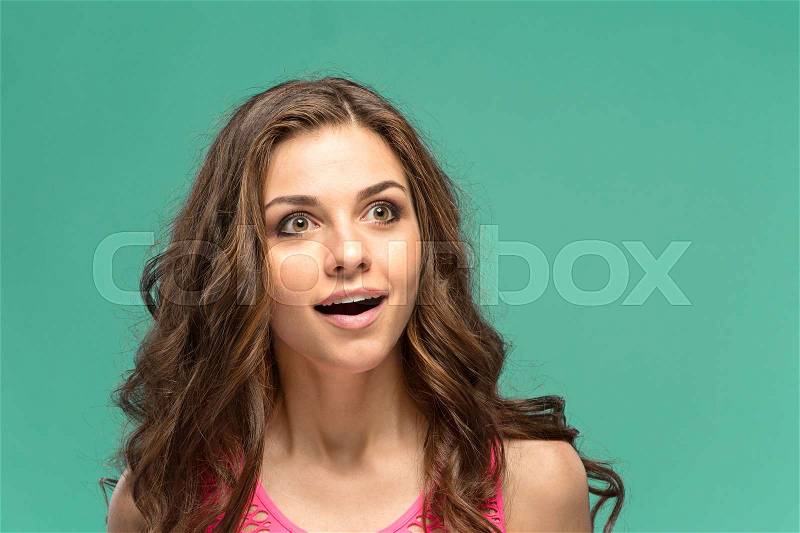 The young woman\'s portrait with happy emotions on green background, stock photo