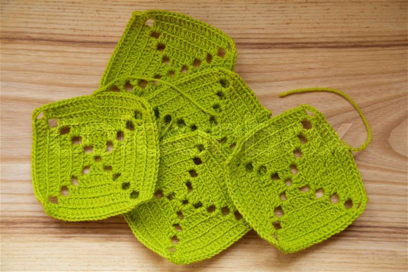 A beautiful hand crocheted pattern pieces of vibrant color gradient in green tones, stock photo