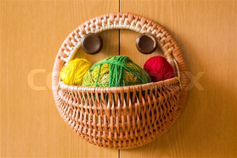 A beautiful, colorful yarn balls in a handmade basket, stock photo