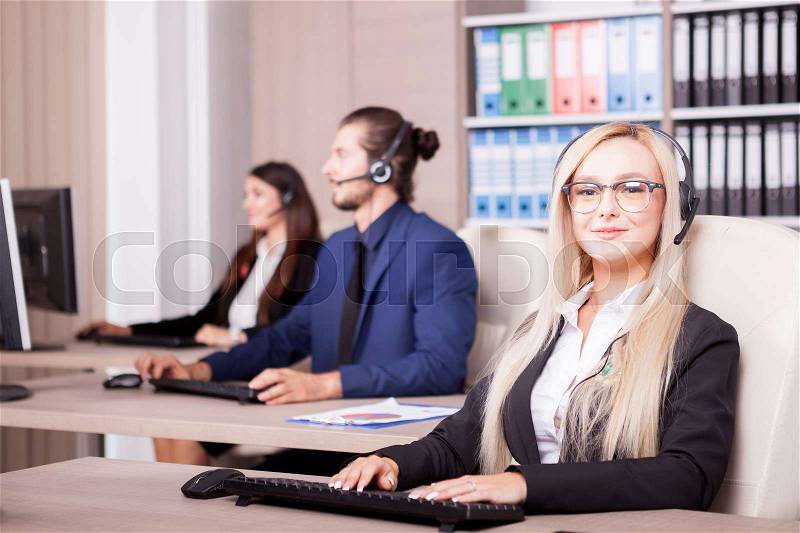 Beautiful blonde from customer support line in office working. Help desk and support, stock photo