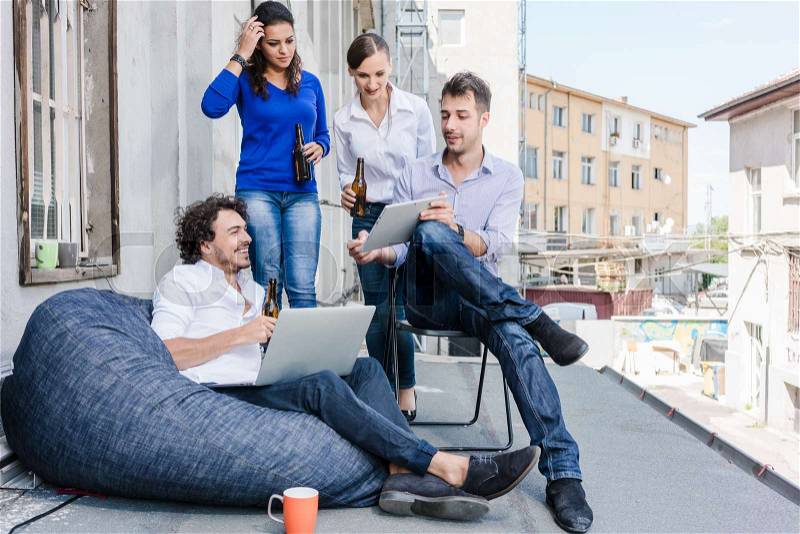 Workmates at creative agency meeting for brainstorming on terrace outdoors, stock photo