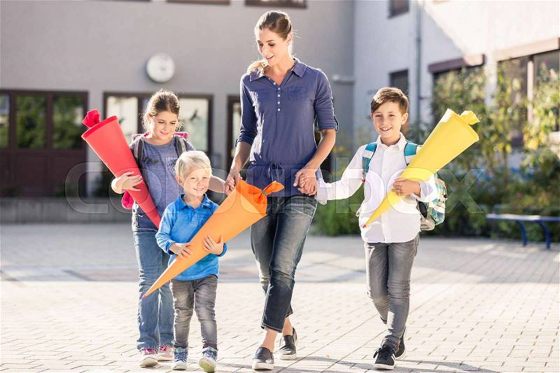 Mum and children with paper funnels for candy after first day at school , stock photo