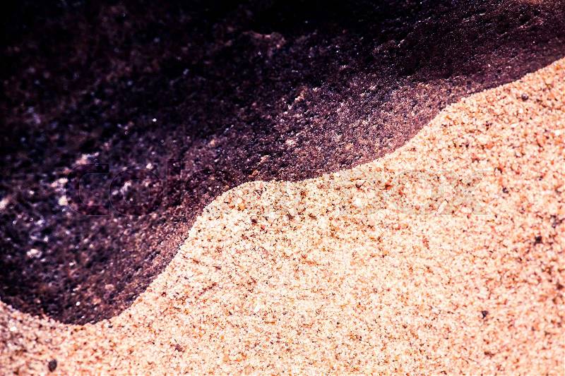 An abstract, high contrast background of a sea sand and rock shapes. Shallow depth of field, purple color tone, stock photo
