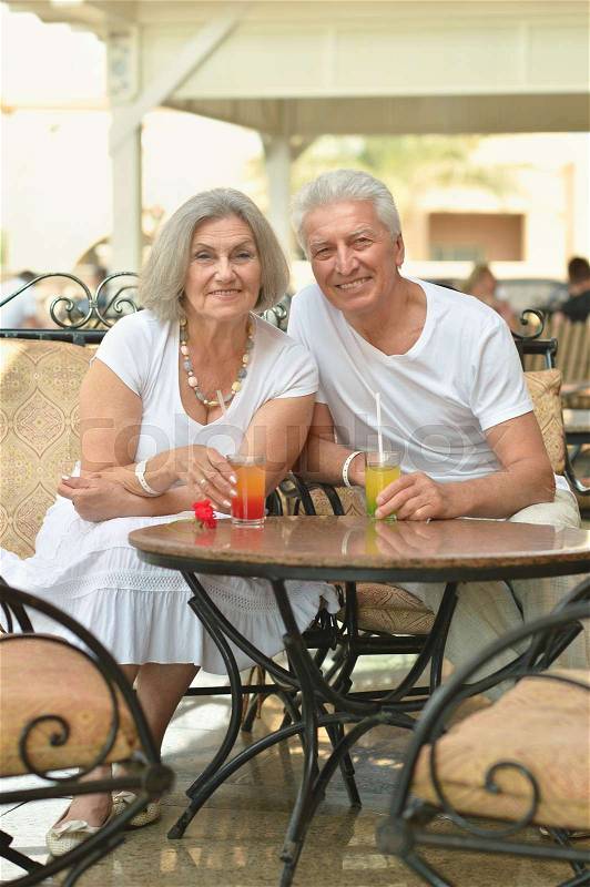 Amusing happy smiling old couple at cafe table, stock photo