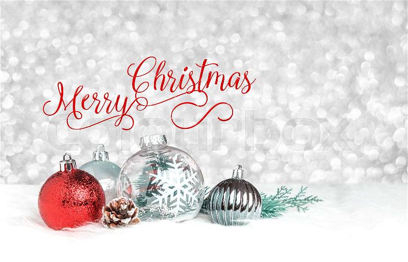 Red Merry Christmas over decoration ball on white fur at silver bokeh light background,Holiday greeting card, stock photo