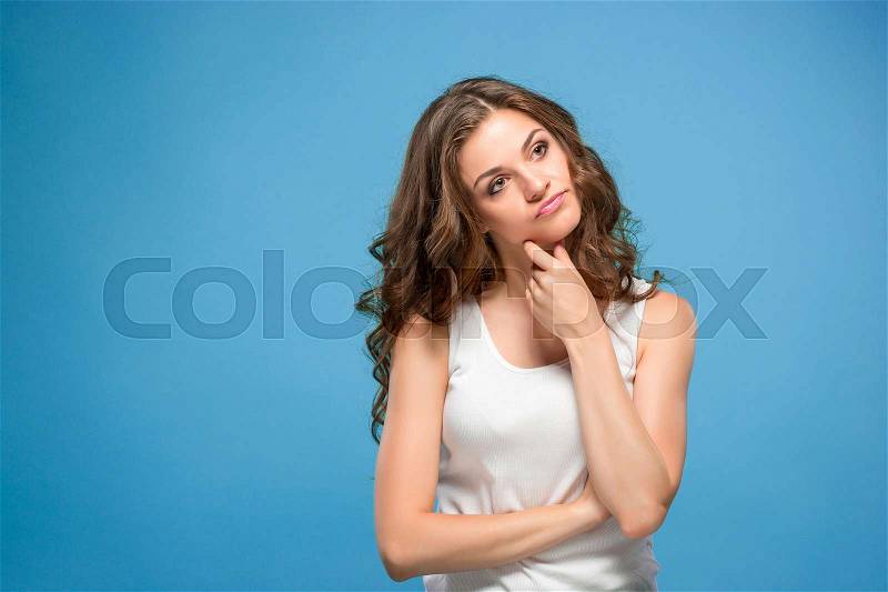 The young woman\'s portrait with sad emotions at studio Presenting something, stock photo