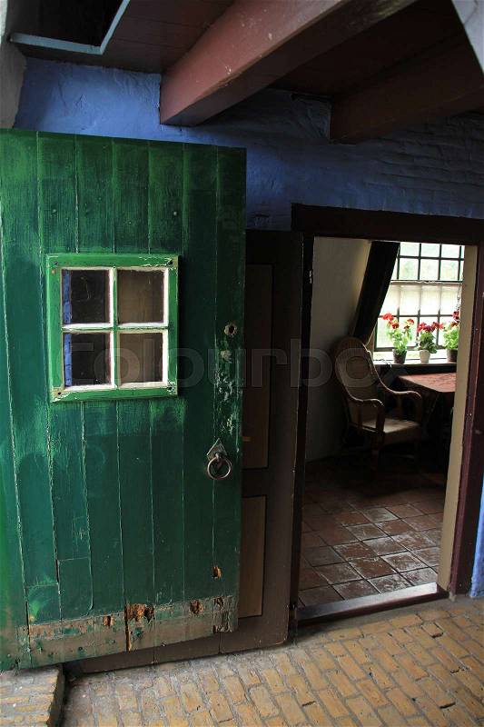 Open door and a glimpse of the small kitchen of the windmill at Kinderdijk in Holland in the summer, stock photo