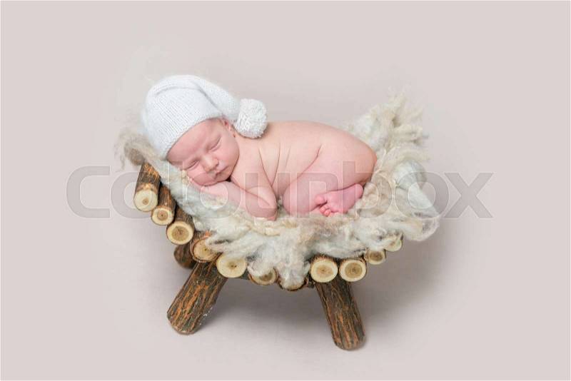 Newborn baby sleeps on a wooden homemade crib, stock photo