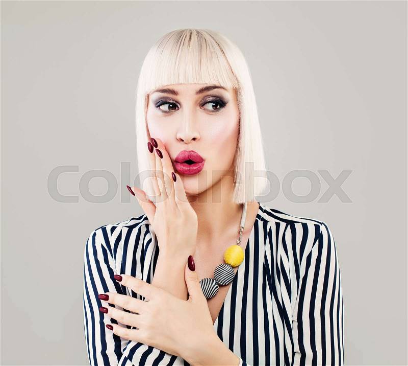 Fashion Portrait of Surprised Woman in Striped Cloth. Beautiful Girl Fashion Model with Makeup, Bob Hairstyle and Manicure on Background with Copy Space, stock photo