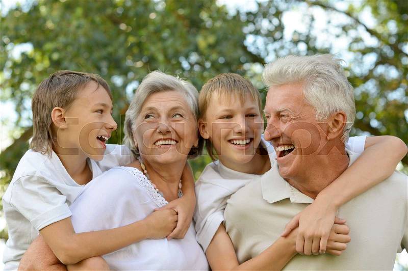 Grandparents with grandsons having fun together outdoors, stock photo