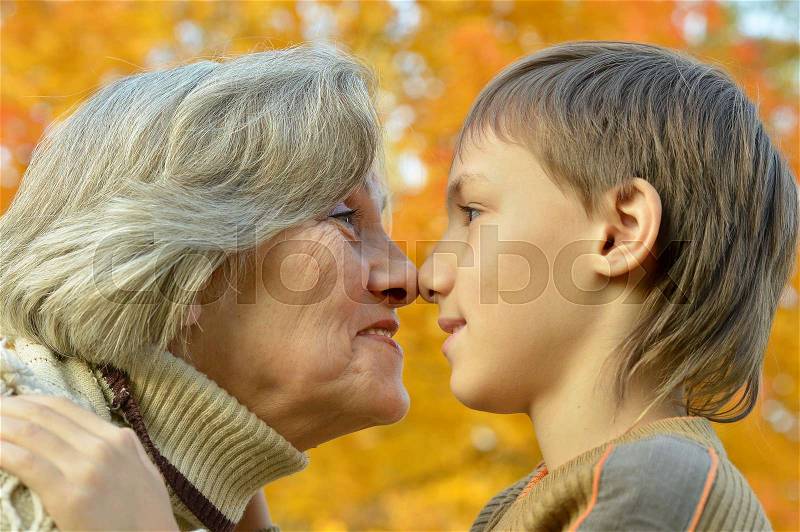 Portrait of a grandmother and grandson posing in park, stock photo