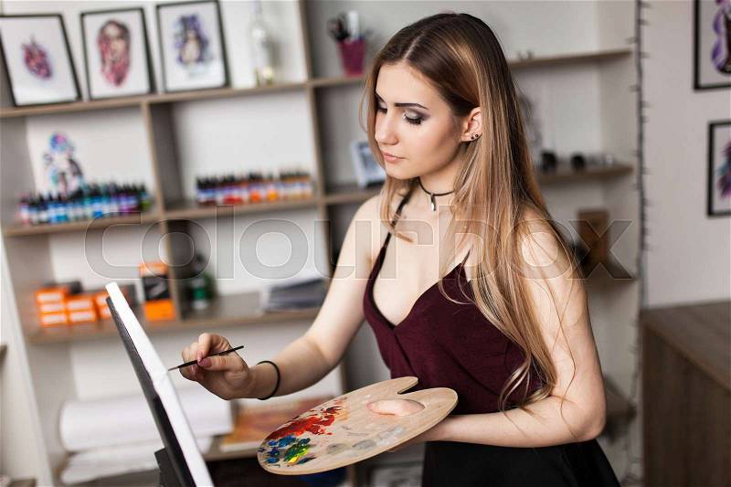 Artist painting in her workshop, stock photo