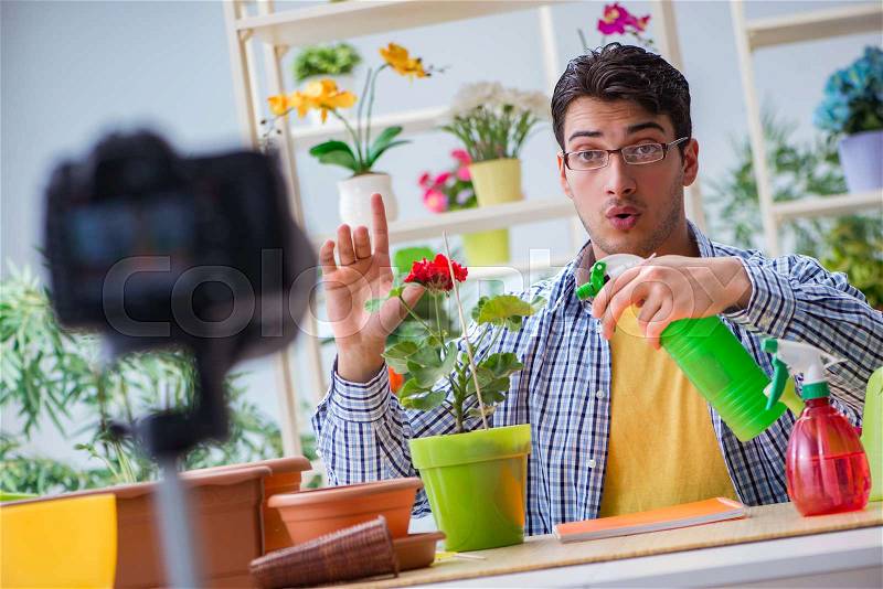 Man florist gardener vlogger blogger shooting video on camera, stock photo