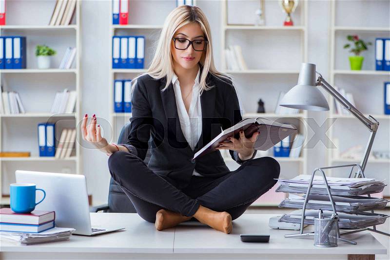Businesswoman frustrated meditating in the office, stock photo