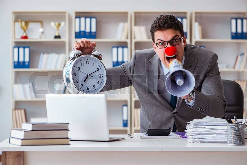Clown businessman angry in the office with a megaphone, stock photo
