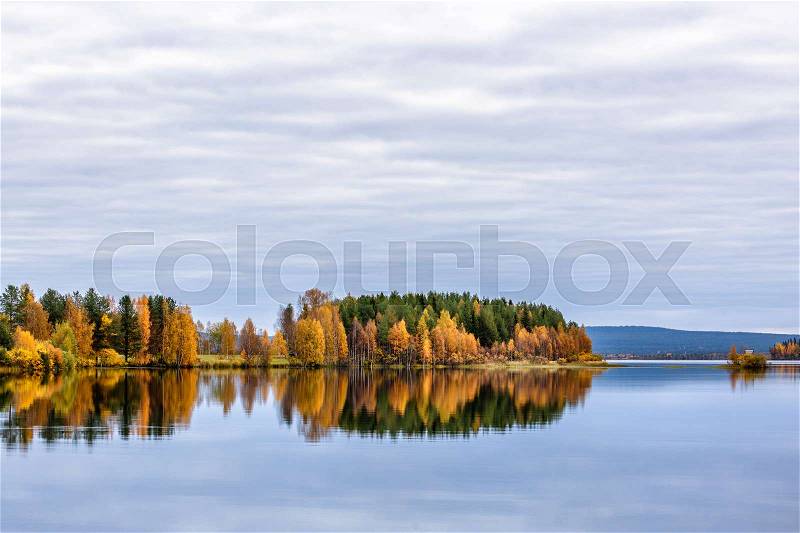 Autumn landscape with colorful forest, lake and reflection, Finland, stock photo