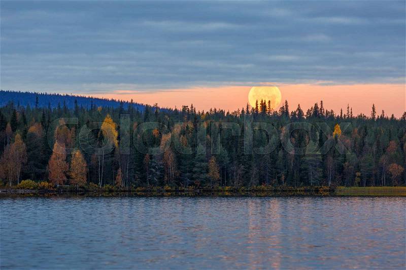 Morning autumn landscape with full moon and lake, Finland, Lapland, stock photo