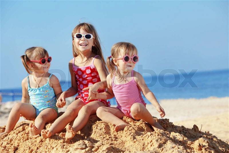 Happy kids playing at the beach in summer, stock photo