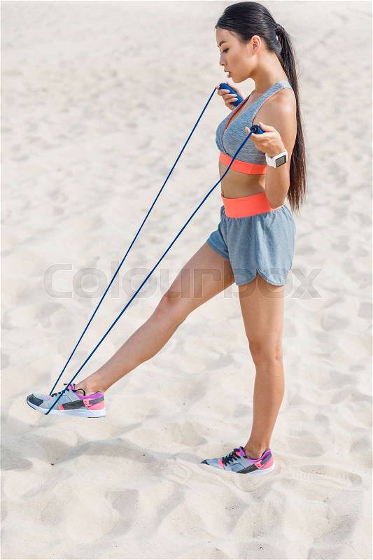 Asian sportswoman training with jump rope, stock photo