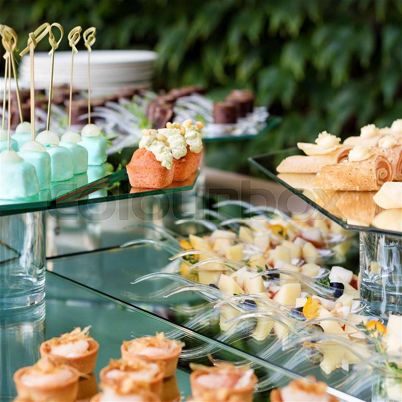 Appetizers, finger food, party food, sliders. Canape, tapas. Served table at summer terrace cafe. Catering service. Outdoor restaurant table with food, stock photo