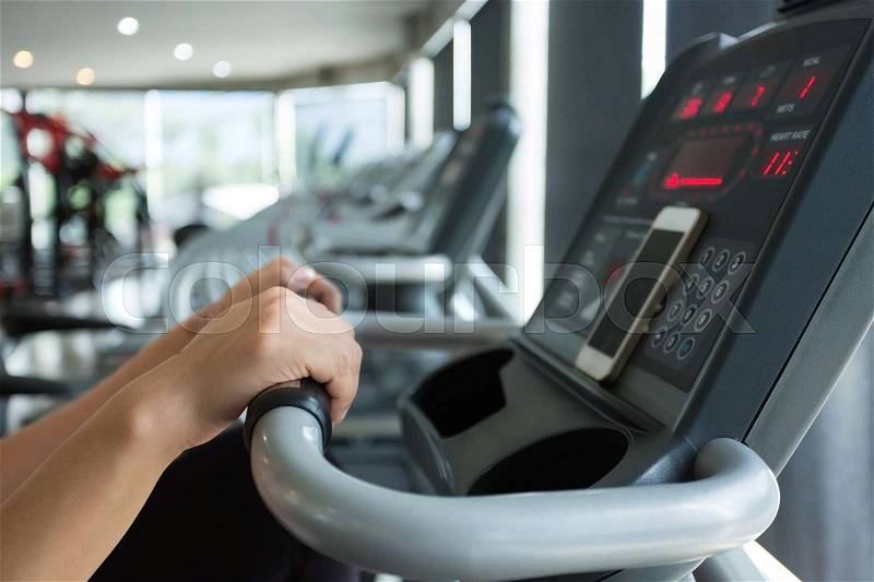 Close-up hand woman cycling burn fat on bicycle cardio machine in fitness gym exercise sport club center , stock photo