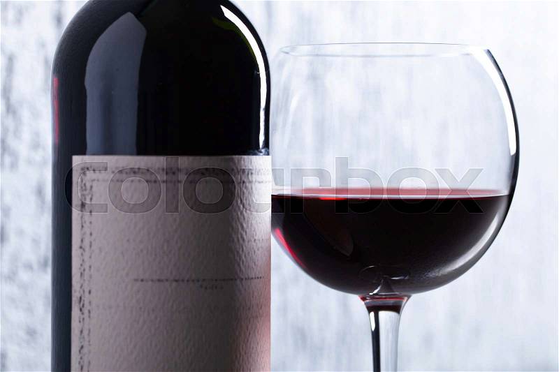 Bottle and glass of red wine . Old paper label . Copy space , stock photo