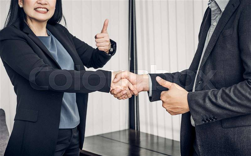 Smile Business woman and business man shaking hand and thumb up in office,Partnership agreement concept,Good solutions, stock photo