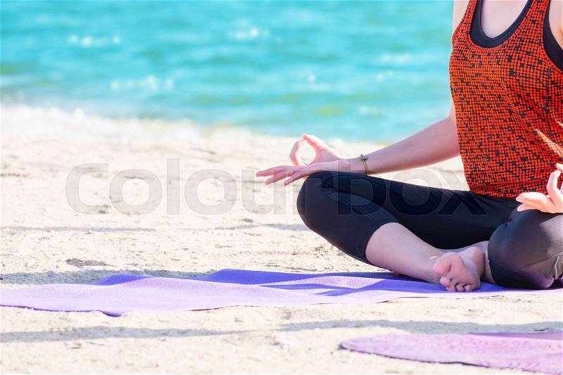 Close up hands of yoga group seated doing Hand Mudra and meditates on sand at coastline beach, Calm and relax concept,wellness and healthy lifestyle, stock photo