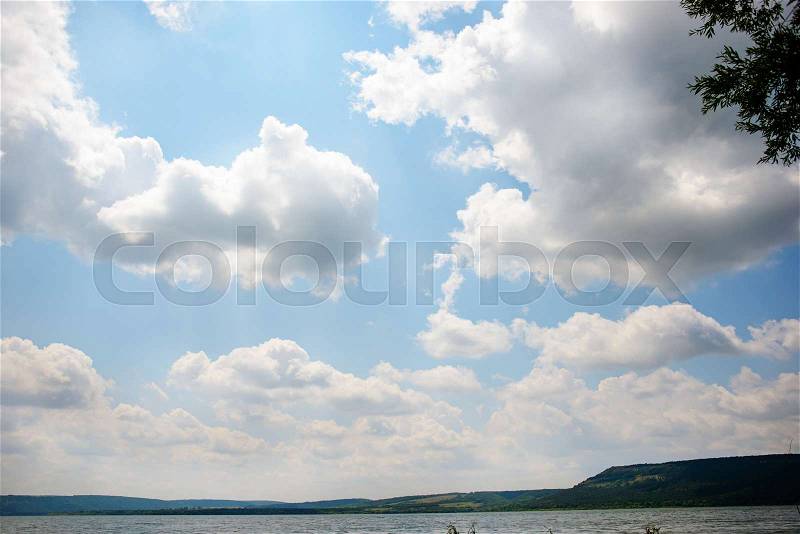 Beautiful lake landscape with mountains, green forests, bright and sunny skies with clouds, stock photo