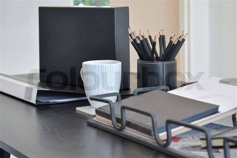Work table with book,pencils, cup of coffee and clock in a home, stock photo